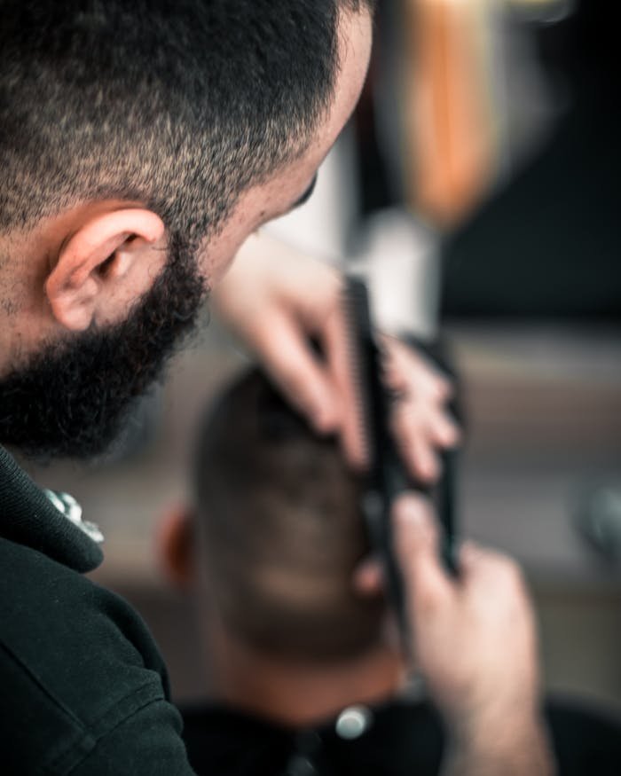 Servicios. Close-up of a barber meticulously cutting a mans hair, focus on detail.